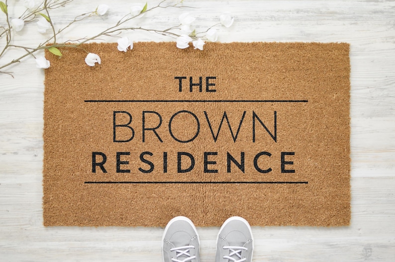 May include: A brown coir doormat with the text "THE BROWN RESIDENCE" in black lettering.