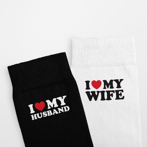 May include: A pair of socks, one black and one white. The black sock has the text "I ❤️ MY HUSBAND" in white with a red heart. The white sock has the text "I ❤️ MY WIFE" in black with a red heart.