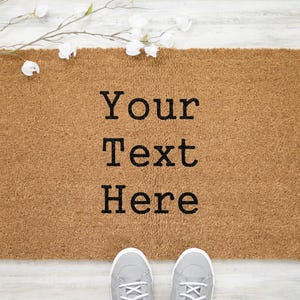 May include: A brown coir doormat with the text "Your Text Here" in black lettering.