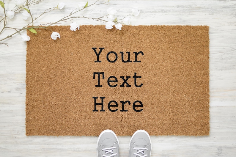 May include: A brown coir doormat with the text "Your Text Here" in black lettering.