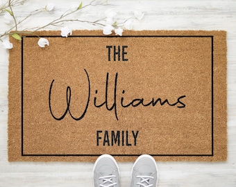 May include: A brown coir doormat with a black border and the text "The Williams Family" in black script font.