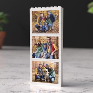 May include: A white photo block with three pictures of a family in a forest setting. The top picture shows a family of five standing in front of a tree. The middle picture shows a family of four sitting on a bench. The bottom picture shows a family of four with a dog.