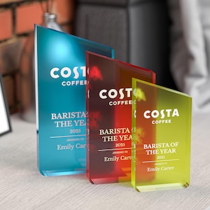 May include: Three acrylic awards in blue, red, and yellow. Each award features the Costa Coffee logo and the text "Barista of the Year 2025" and "Awarded to Emily Carter."