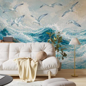 May include: A wall mural featuring a painted scene of white seagulls flying over turbulent, deep blue ocean waves with white sea foam. The artwork displays a dynamic coastal theme with textured brushstrokes across the entire wall surface.