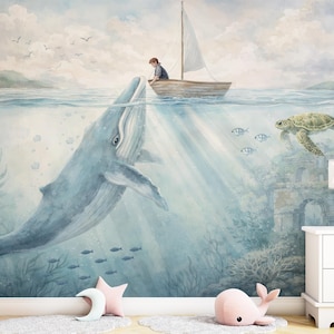 Puede incluir: Un mural caprichoso representa una escena submarina con una gran ballena azul, un velero y una tortuga marina. La obra de arte presenta un niño en el barco, peces y una paleta de colores suaves, creando una atmósfera de ensueño.
