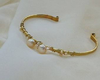 Wire wrapped gold colored brass bracelet with a variety of iridescent freshwater pearls in champagne color. (114)