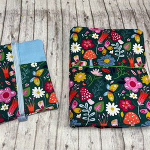 May include: Two fabric pouches with a floral and butterfly design. The larger pouch is green with red, yellow, white, and blue flowers and butterflies. The smaller pouch is green with a light blue section and a zipper.