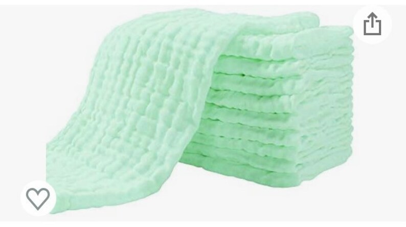 May include: A stack of light green muslin cloths, folded and arranged in a pile. The cloths are soft and textured, with a waffle-like pattern.