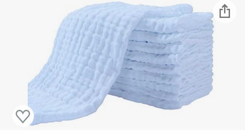 May include: A stack of 10 soft, white, muslin cloths with a textured waffle weave. The cloths are folded and stacked neatly.