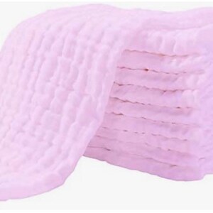 May include: A stack of pink muslin cloths, folded and ready to use. The cloths are soft and absorbent, making them ideal for a variety of uses, including baby care, cleaning, and crafting.