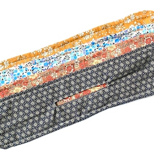 May include: A set of five fabric strips with different floral patterns. The strips are sewn together and have a geometric pattern on the bottom.
