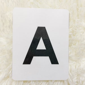 May include: White card with the letter A printed in black.