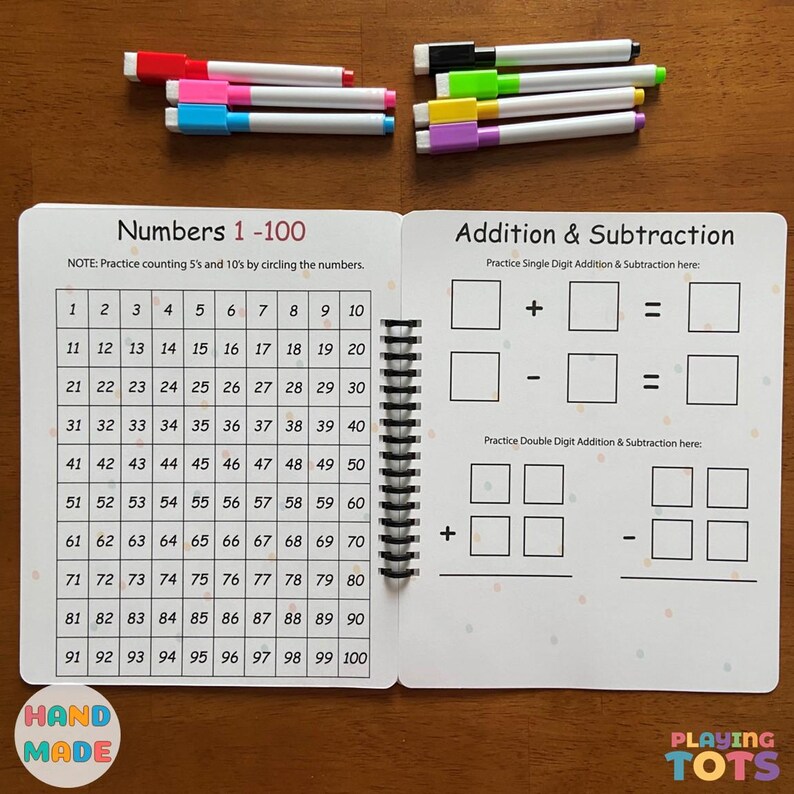 May include: A spiral-bound educational activity book for children, featuring number practice from 1 to 100 and addition/subtraction exercises. Includes colorful markers in various colors. The book is labeled "Hand Made" and "Playing Tots".