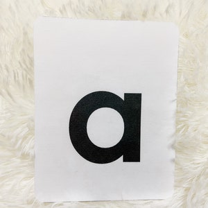 May include: A white card with a black letter 'a' printed on it.