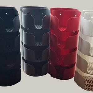 Puede incluir: Cuatro contenedores de almacenamiento apilables en negro, gris, rojo y blanco. Cada contenedor tiene cuatro compartimentos con un patrón de panal.