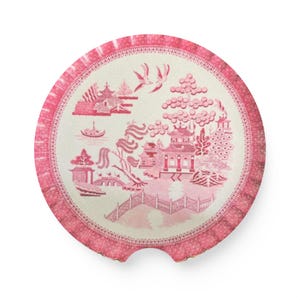 Puede incluir: Un posavasos redondo rosa y blanco con un diseño clásico de patrón Willow. El diseño presenta un puente, una pagoda y pájaros. El posavasos tiene un borde festoneado y un pequeño recorte.