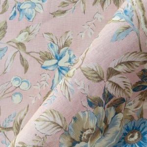 May include: Pink fabric with a floral pattern featuring blue and brown flowers. The fabric has a soft, delicate feel and is perfect for crafting projects.