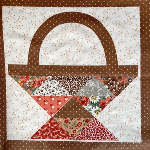 May include: A brown fabric basket with a patchwork design. The basket is made of various fabrics with floral and geometric patterns in shades of red, brown, and white.