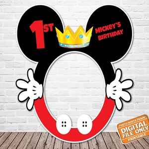 Puede incluir: Un accesorio de fotomatón de Mickey Mouse rojo y negro con una corona dorada y el texto "1st" y "Mickey's Birthday".