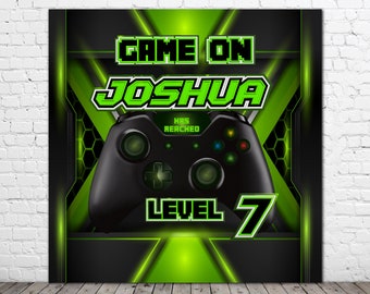May include: A green and black video game themed backdrop with a black Xbox controller in the center. The text "GAME ON" is at the top and "JOSHUA HAS REACHED LEVEL 7" is below the controller.