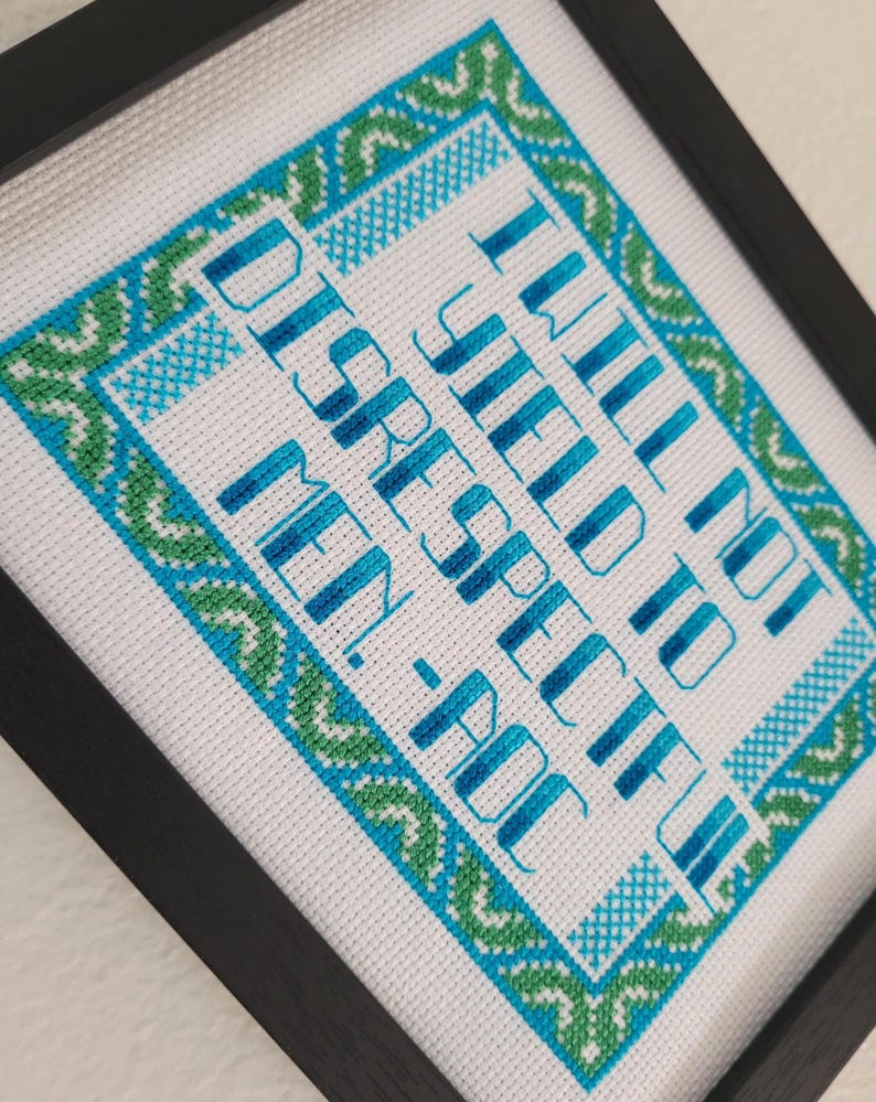 Puede incluir: Arte de punto de cruz enmarcado. La tela blanca presenta un dise&ntilde;o de borde turquesa y verde y texto turquesa que dice: "I WILL NOT BE DISRESPECTFUL TO MEN-POC."
