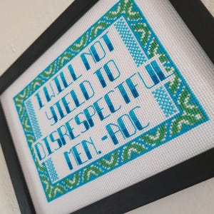 Puede incluir: Arte de punto de cruz enmarcado. El texto dice "I WILL NOT YIELD TO DISRESPECTFUL MEN - POC" en azul y blanco. El borde es un patr&oacute;n repetitivo de formas geom&eacute;tricas azules y verdes.