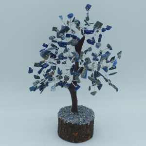 May include: A wire tree sculpture with a wooden base. The tree is decorated with blue lapis lazuli stones.