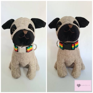 May include: A plush grey and black pug dog toy with a red, yellow, and green striped collar. The collar has a silver buckle.