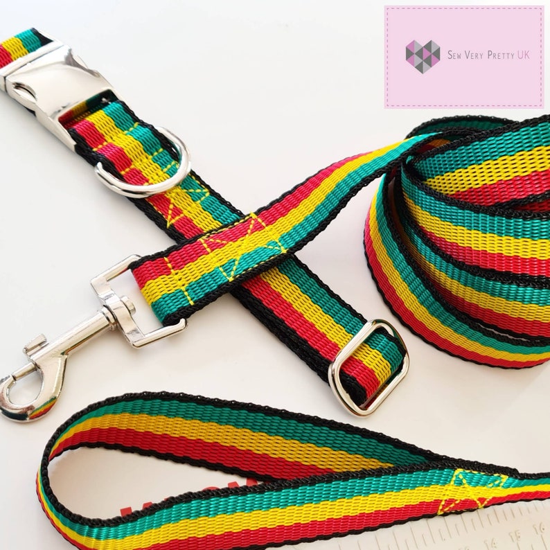 May include: A red, yellow, and green striped dog collar and leash set with silver hardware. The collar has a buckle closure and the leash has a metal ring.