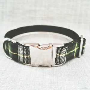 Puede incluir: Un collar de perro de cuadros negros y verdes con una hebilla plateada.