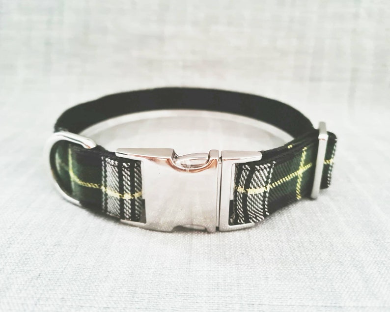 Puede incluir: Un collar de perro de cuadros negros y verdes con una hebilla plateada.