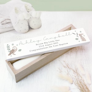 May include: A rectangular wooden box with a white lid featuring the printed text Ashley Campbell, Dream Big Little One, 23rd August 2022, Congratulations On Your Baptism, decorated with illustrations of an owl, a rabbit, and stars.