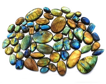May include: A collection of polished labradorite gemstones in various shapes and sizes. The stones display a range of colors, including blues, greens, yellows, and browns, with iridescent flashes. The gemstones are oval, teardrop, and rectangular.