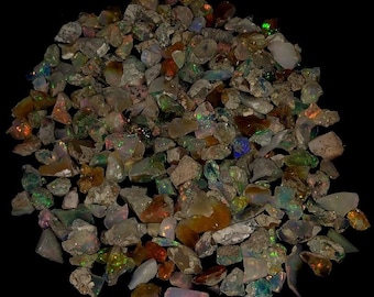 Könnte beinhalten: Ein großer Haufen roher, unpolierter Opal-Edelsteine. Die Opale sind in verschiedenen Grüntönen, Braun-, Rot- und Weißtönen mit schillernden Farbflecken.