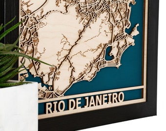 May include: A wooden map of Rio de Janeiro, laser cut and mounted in a black frame with a teal blue background. The map is raised and has a 3D effect.