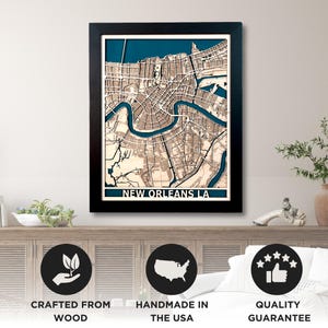 May include: Framed wooden map of New Orleans, LA, with a detailed street layout and the Mississippi River in blue. The map is set in a black frame and features the text "NEW ORLEANS LA".