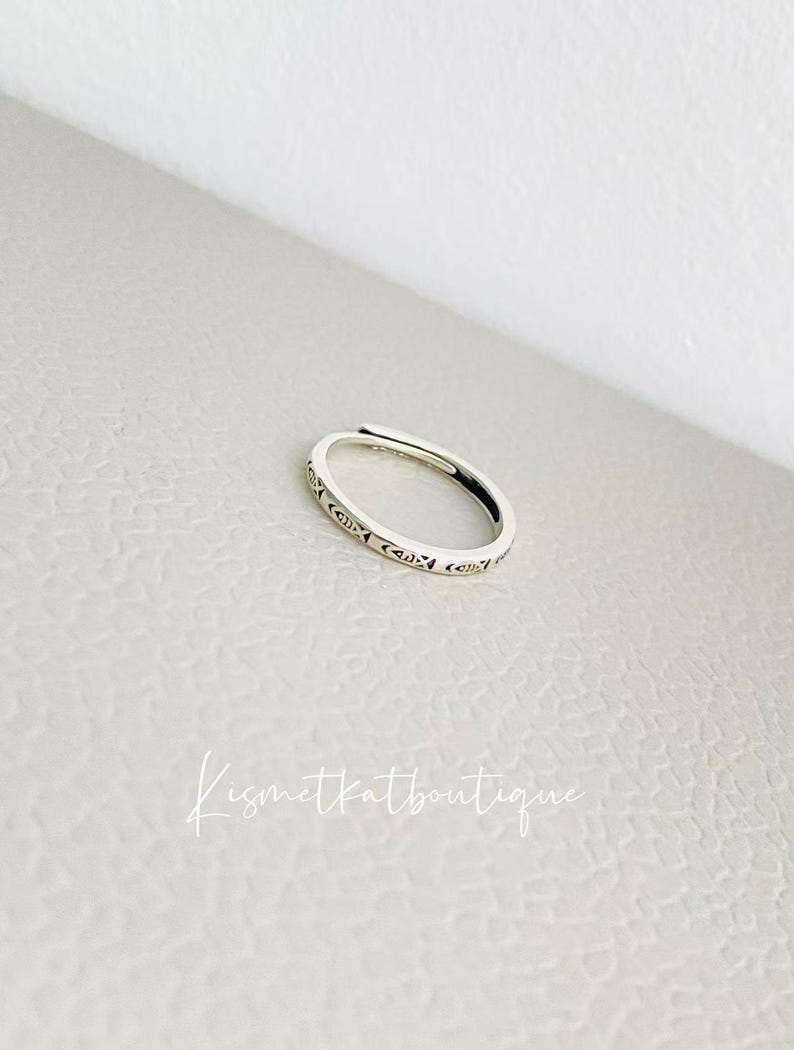 May include: A silver ring with a delicate, intricate design. The ring is simple and elegant, perfect for everyday wear.