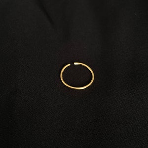 May include: A simple gold ring, a minimalist jewelry piece.
