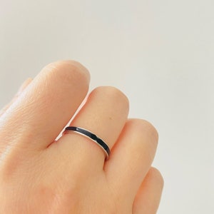 Pu&ograve; includere: Un sottile anello a fascia d'argento con una striscia di smalto nero.