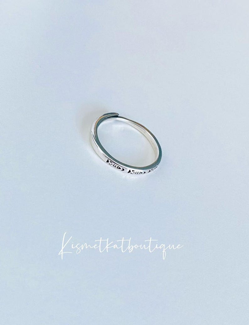 May include: A silver ring with a delicate design. The ring is simple and elegant, perfect for everyday wear.