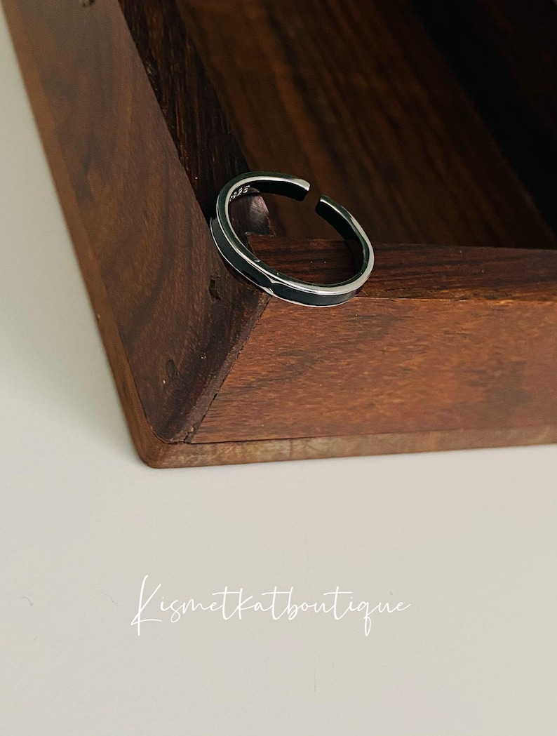 Pu&ograve; includere: Un anello d'argento con una fascia larga, posto in una scatola di legno.