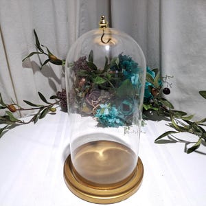 May include: A white ceramic mug with a black handle and the text "But First, Coffee" in a black, handwritten-style font. The mug is on a white surface.