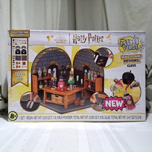 May include: A Harry Potter Mini Verse Potion Class set. The box features a diorama of a potions classroom with a table, shelves, and various potion bottles. The set includes over 100 pieces and is marked as new.
