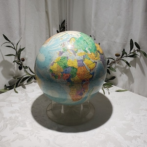 May include: A blue globe with a colorful map of the world on it. The globe is on a clear plastic stand.