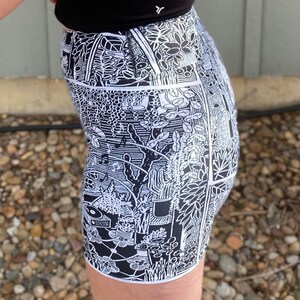 May include: Black and white patterned shorts with a botanical design. The shorts are made of a stretchy fabric and have a high waist.