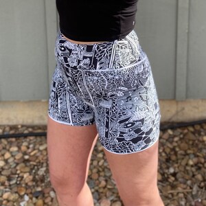 May include: Black and white patterned athletic shorts with a high waist and a black crop top.