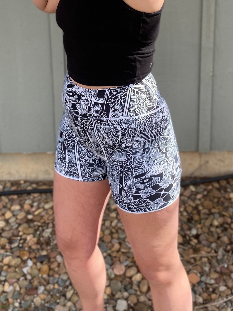 May include: Black and white patterned athletic shorts with a high waist and a black crop top.