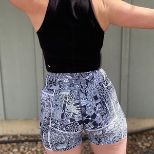 May include: Black tank top and black and white patterned athletic shorts. The shorts have a white outline and a black and white graphic print.