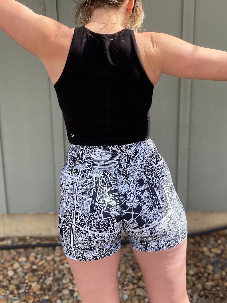 May include: Black tank top and black and white patterned athletic shorts. The shorts have a white outline and a black and white graphic print.