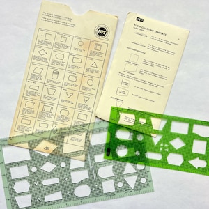 May include: Two off-white paper reference guides for flowcharting symbols and two translucent green plastic templates with various geometric cutouts for drawing flowcharts. The templates feature printed grid lines and measurement markings in inches.